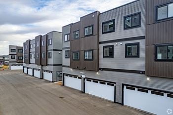 A series of modern townhouses with garages in front.